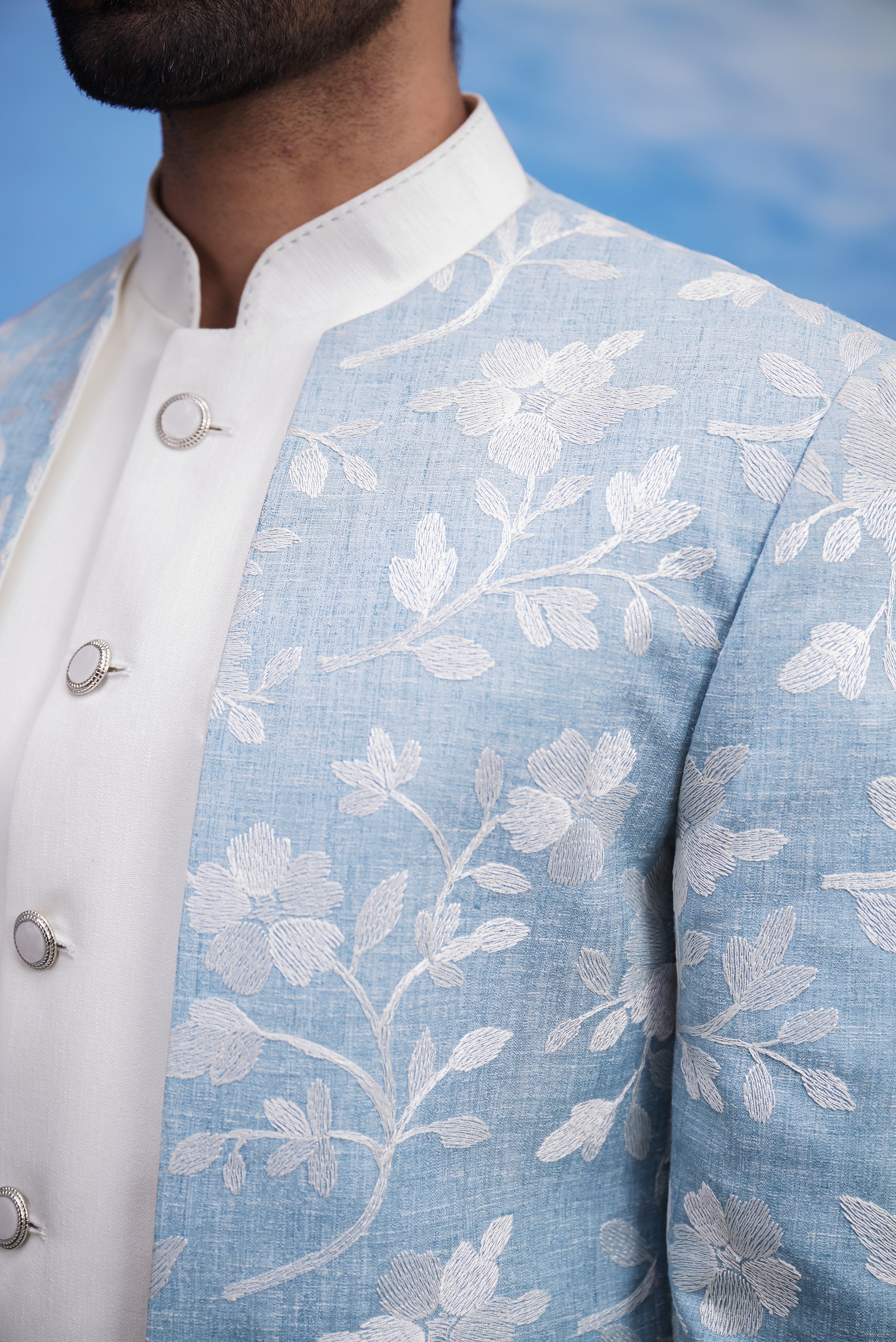 Men's light blue Bandhgala suit with an open front design and linen fabric, displayed on a product page with size options.