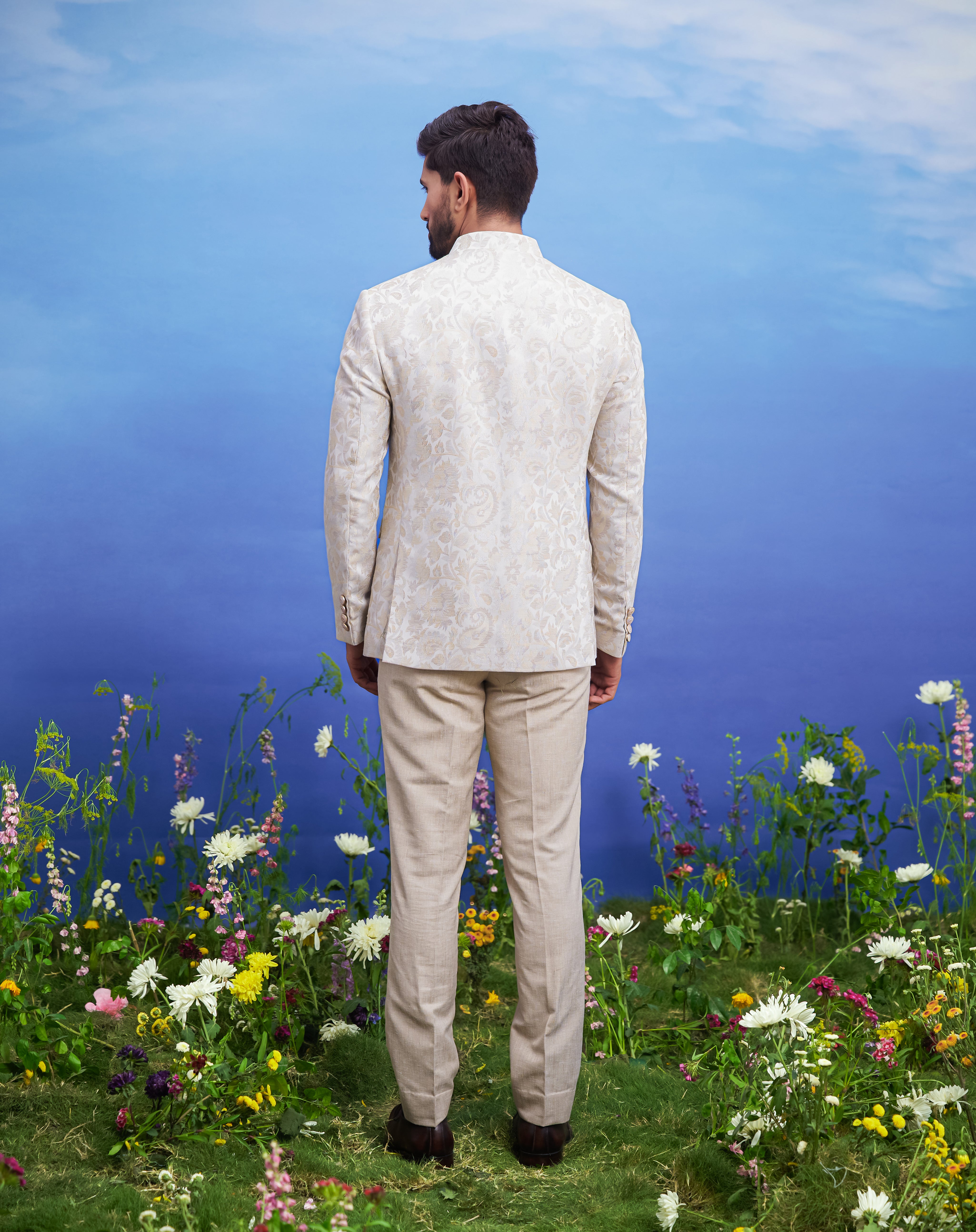 Men's beige Bandhgala suit with jacquard pattern and linen jacket, displayed on a product page with size options.