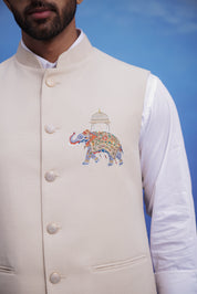 Close-up of the beige Nehru jacket, highlighting the embroidered motif and linen blend fabric.