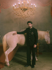 A man in a latest fashion black jodhpuri suit is standing