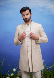 Men's cream Indo-western ensemble with floral embroidery and intricate zari detailing, ideal for wedding attire.