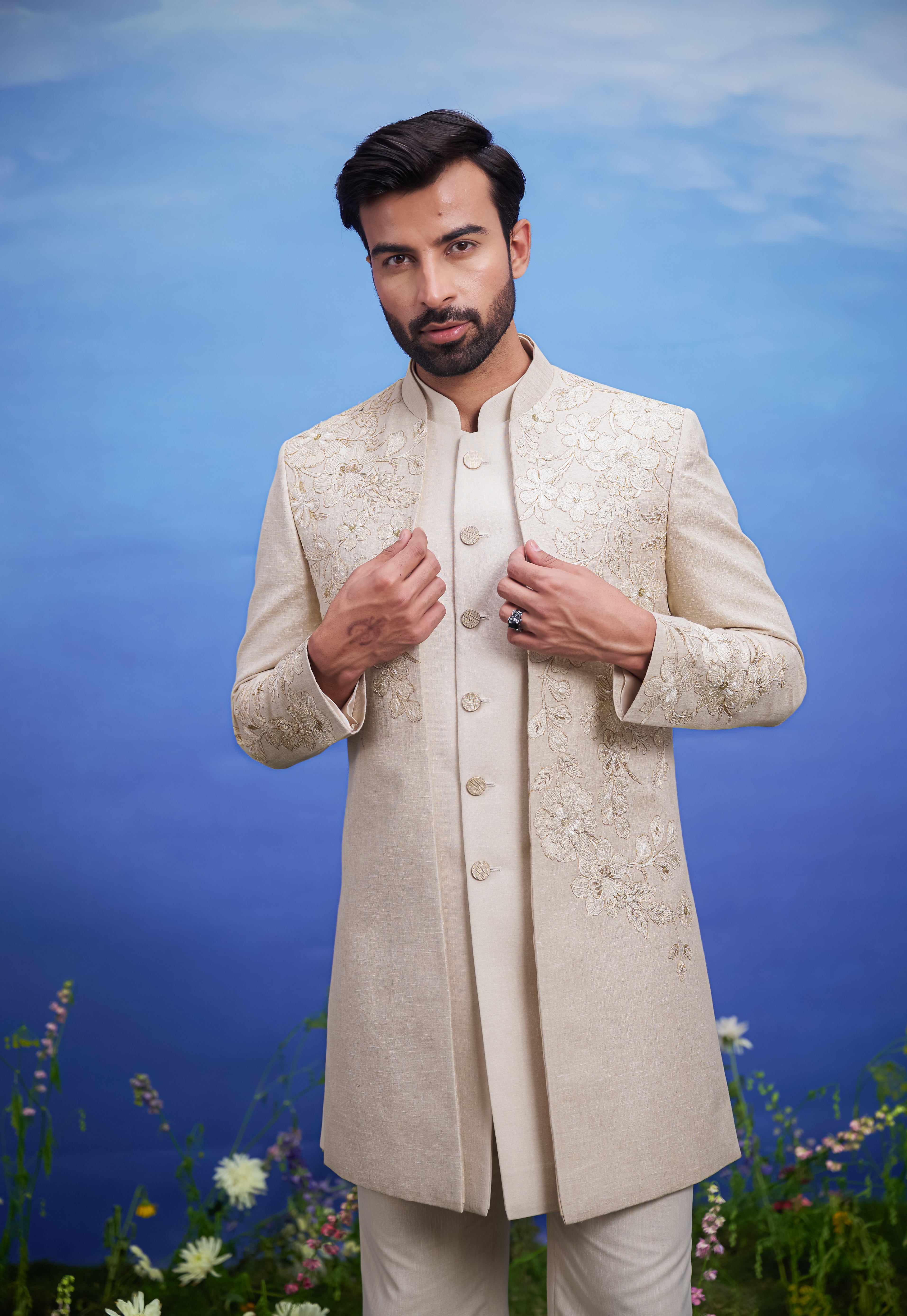 Men's cream Indo-western ensemble with floral embroidery and intricate zari detailing, ideal for wedding attire.
