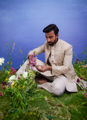 A sophisticated cream Indo-western suit with floral embroidery and zari detailing, ideal for formal occasions.