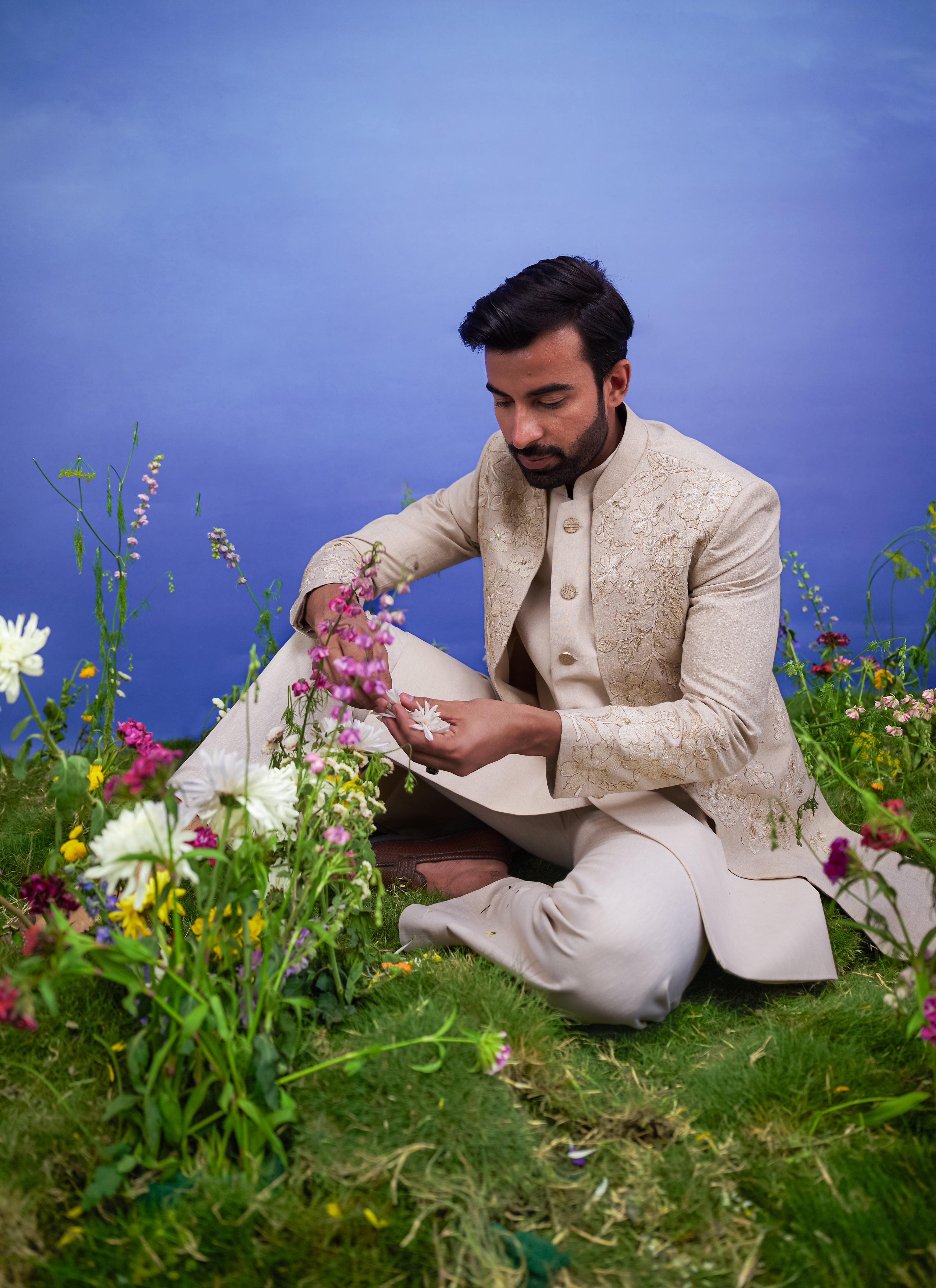 A sophisticated cream Indo-western suit with floral embroidery and zari detailing, ideal for formal occasions.