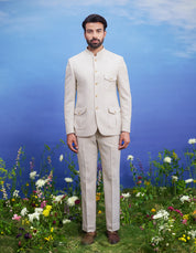 Men's cream patch pocket Bandhgala suit featuring a textured Bandhgala, mid-rise trousers, pocket square, and pin.