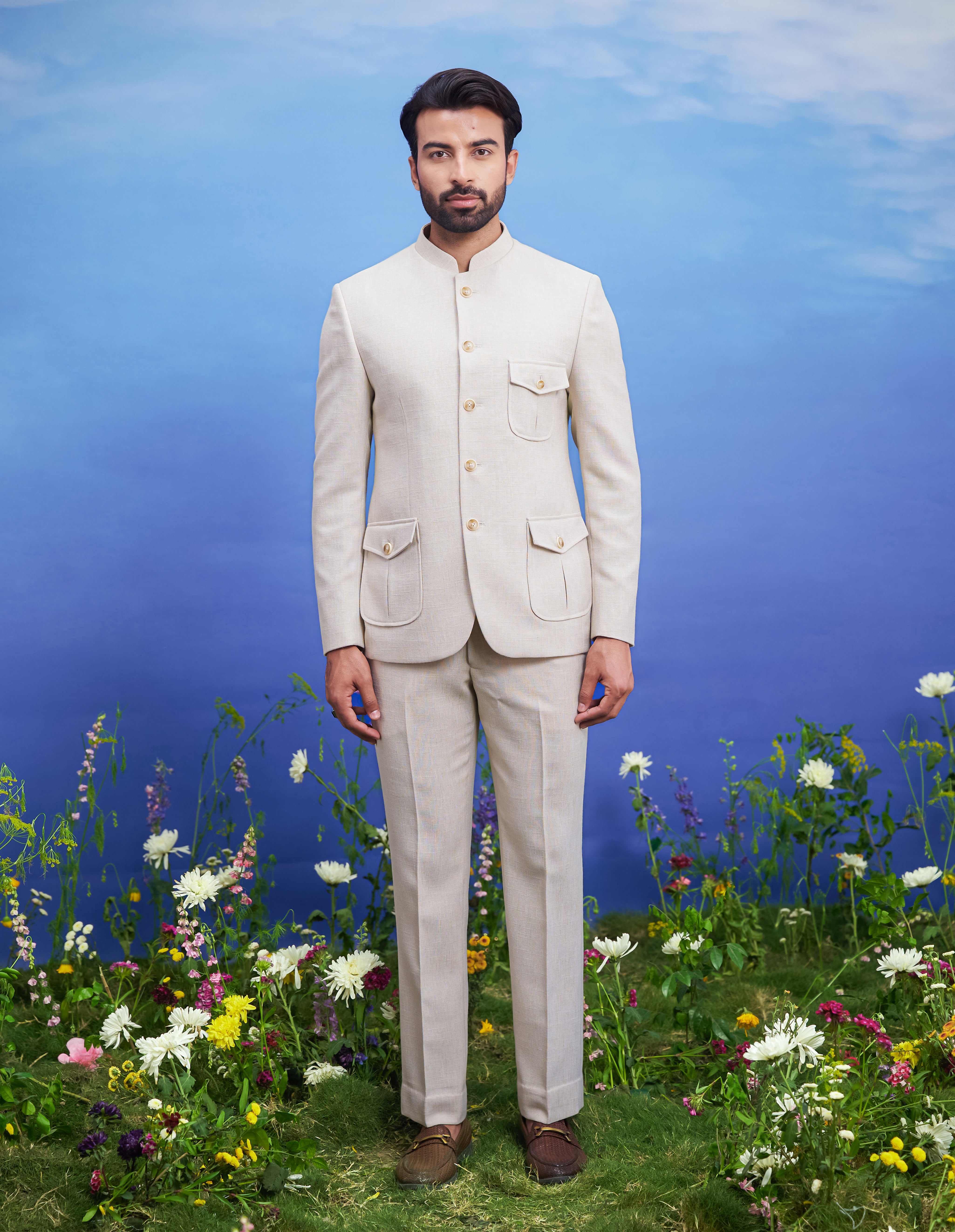 Men's cream patch pocket Bandhgala suit featuring a textured Bandhgala, mid-rise trousers, pocket square, and pin.