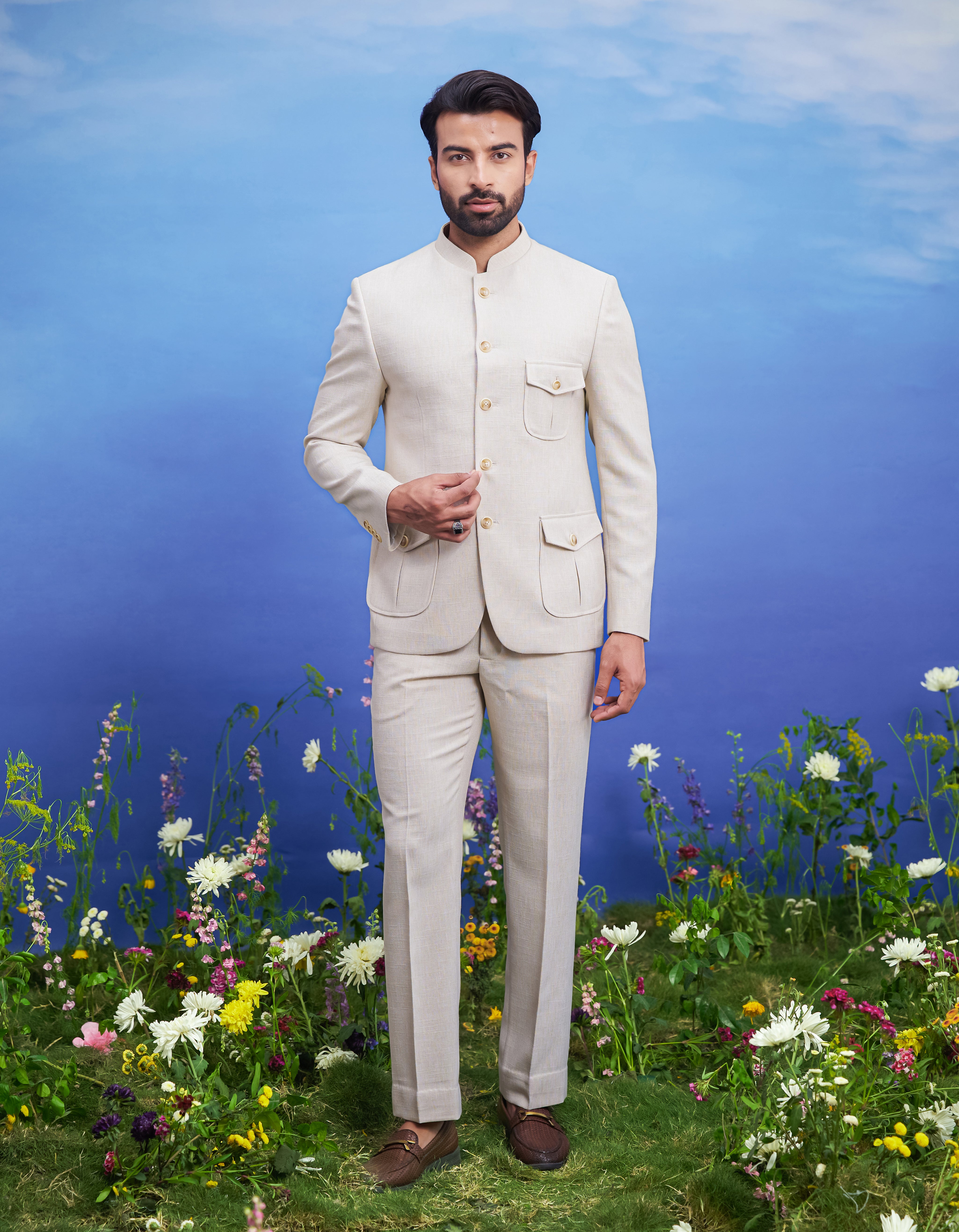 Cream patch pocket Bandhgala suit, men's ethnic formal wear, featuring a textured Bandhgala, trousers, pocket square, and pin.