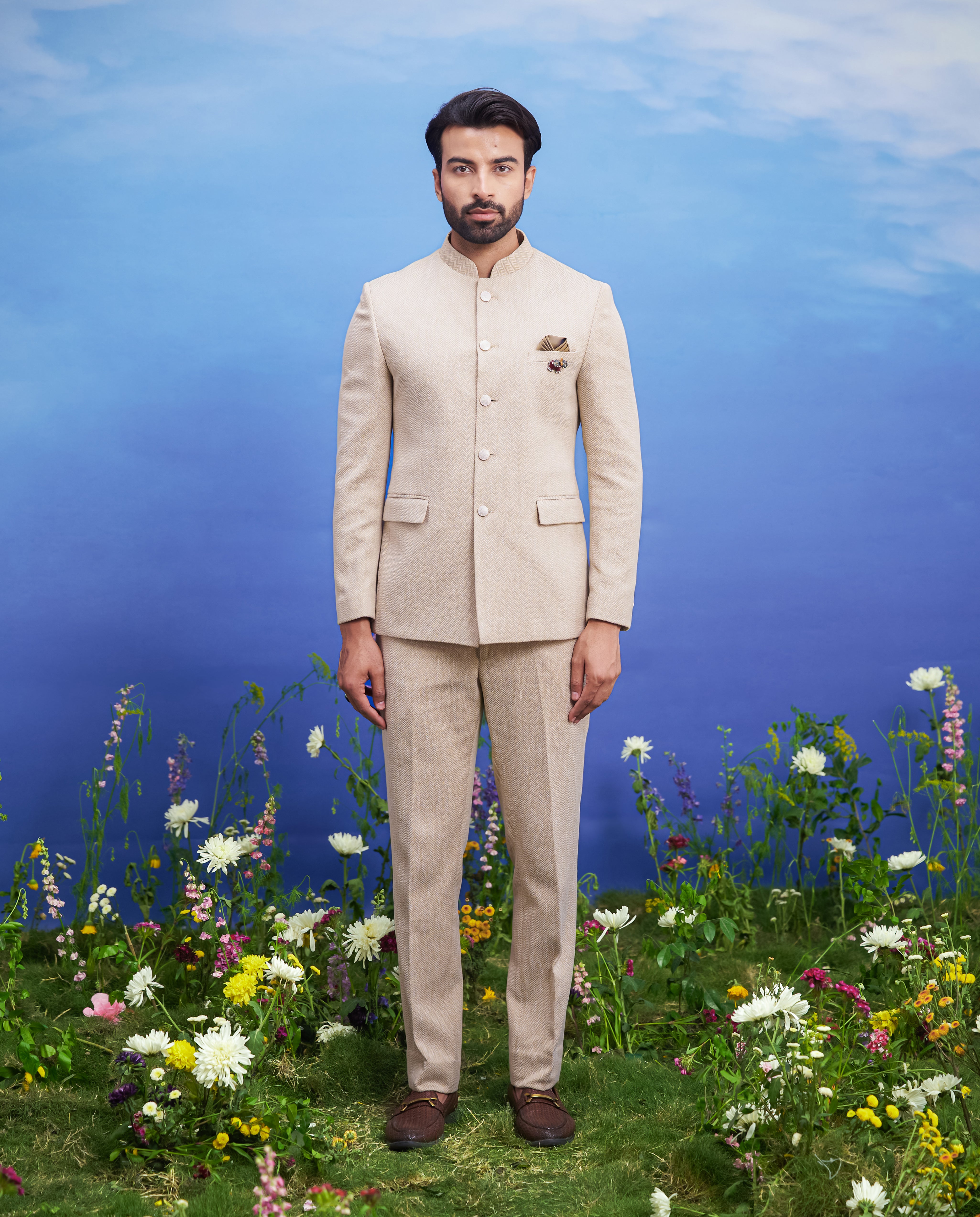 Men's beige Herringbone structured Bandhgala suit featuring a tailored Bandhgala, mid-rise trousers, pocket square, and pin.