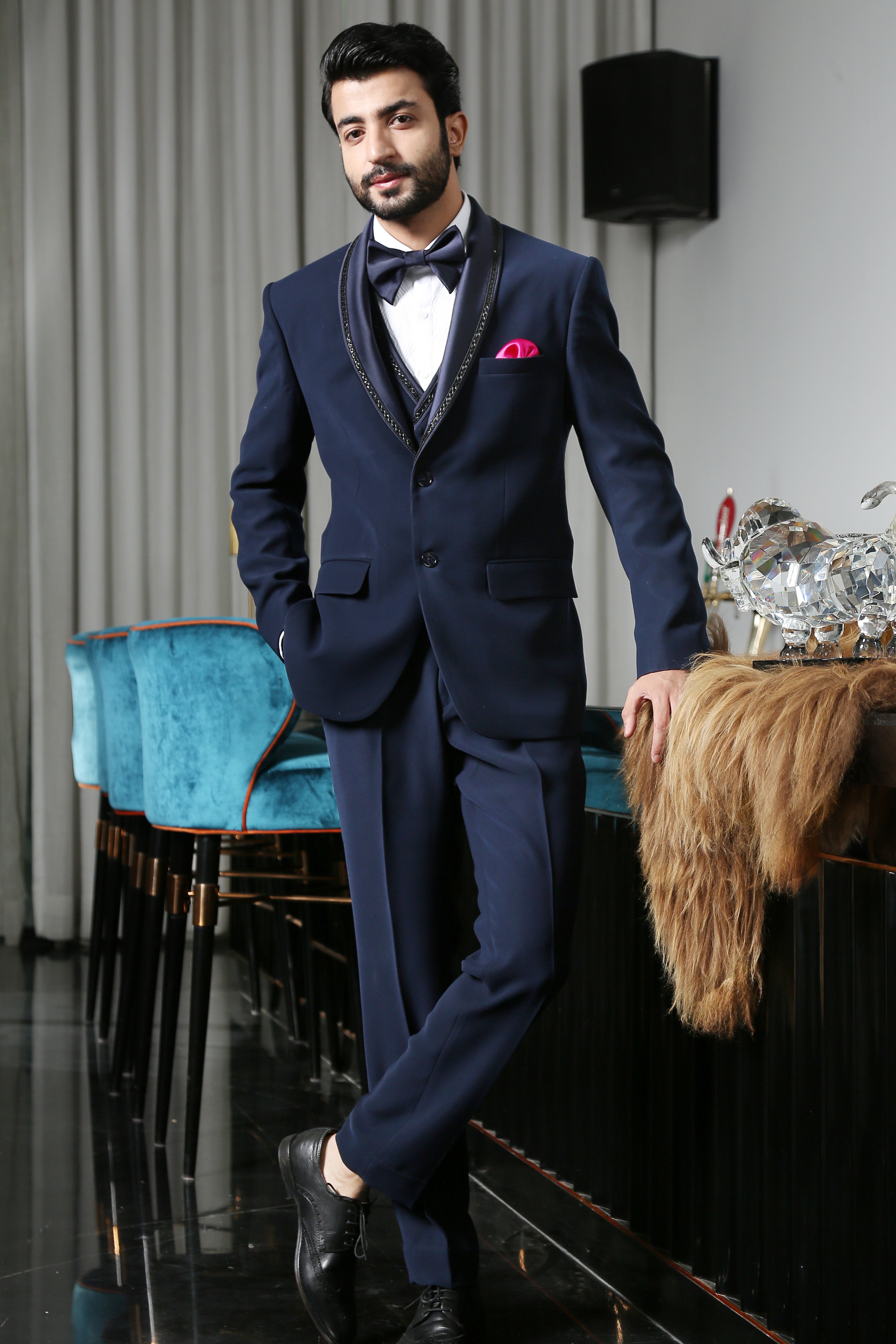 A luxurious navy blue designer suit with intricate embroidery, a timeless classic.
