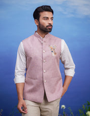 A pink Nehru jacket with an embroidered motif, featuring a mandarin collar and two front pockets, ideal for men's party wear.