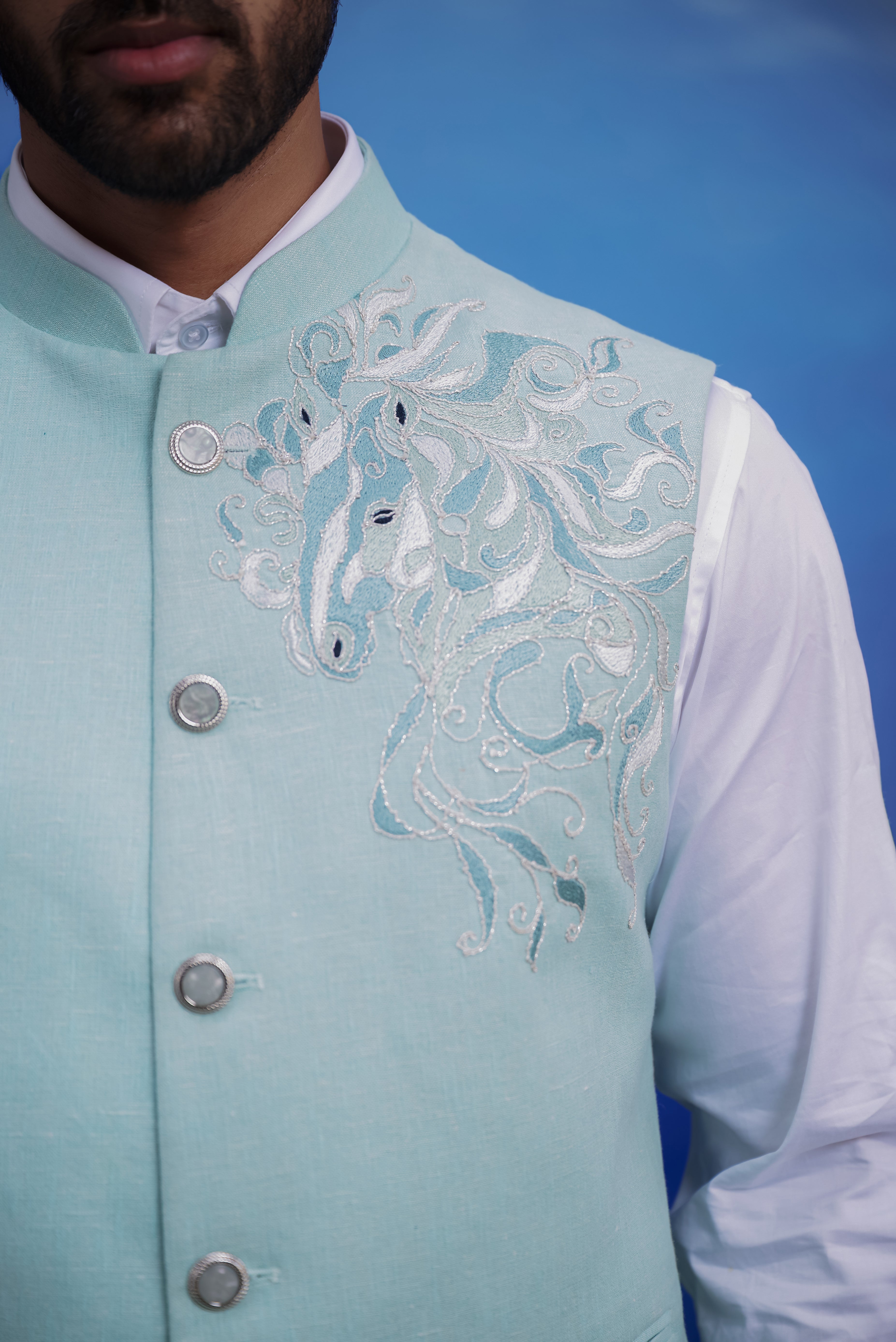Close-up of the pista green linen Nehru jacket, highlighting the embroidered motif and linen fabric.