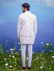A white kurta jacket set with a floral print, featuring a kurta, jacket, and pajama, ideal for men's ethnic wear.